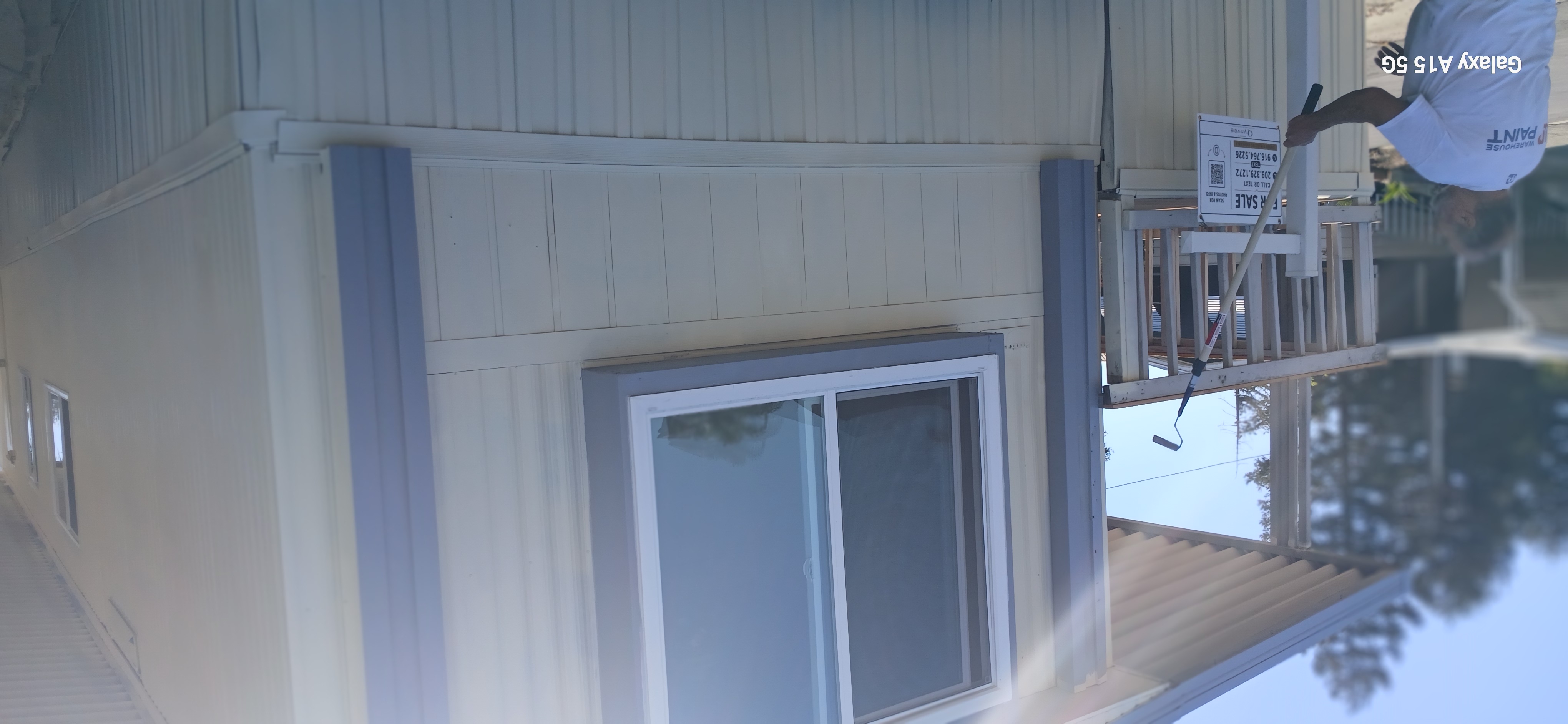 Front of the home with blue trim, a large window, and covered porch