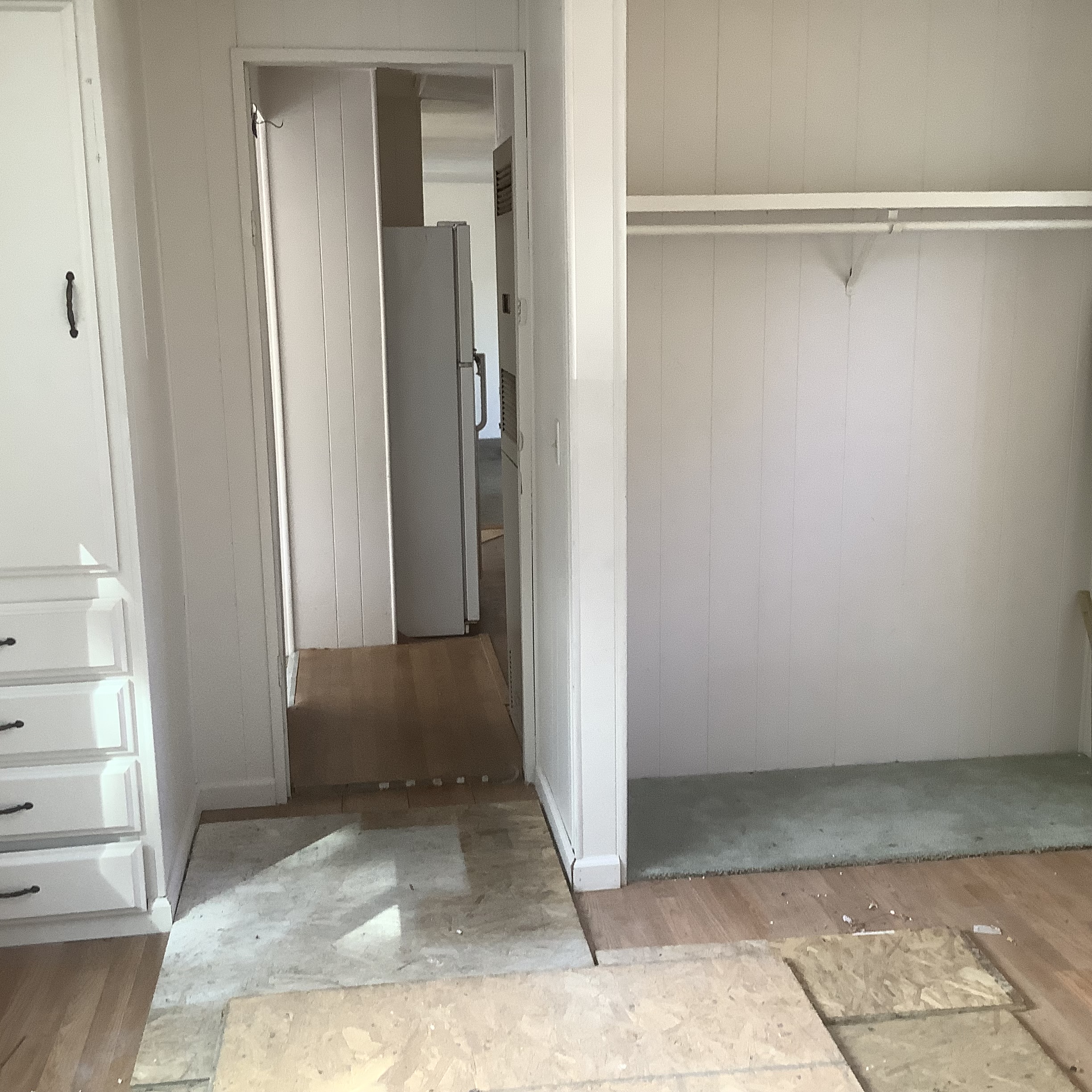 Interior room with built-in drawers, closet space, and exposed flooring