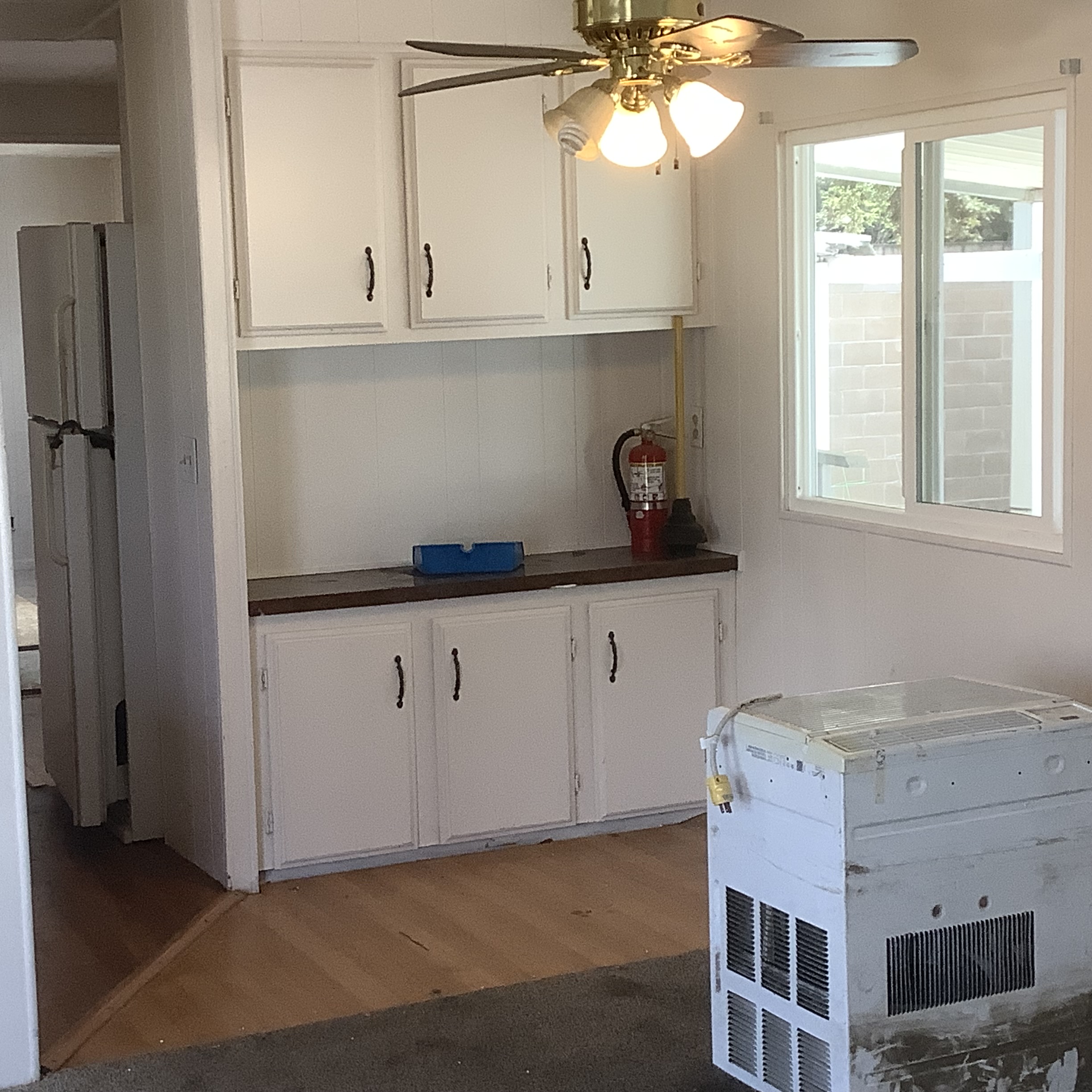 Interior with built-in cabinets, ceiling fan, and an appliance in the foreground
